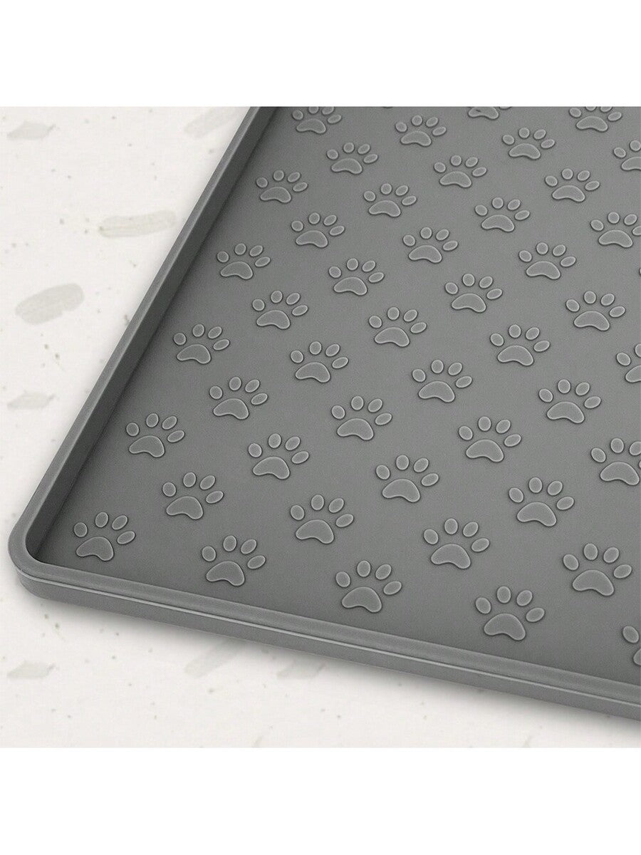 Beige silicone pet placemat with embossed paw print accents designed to catch food and water spills for dogs and cats.