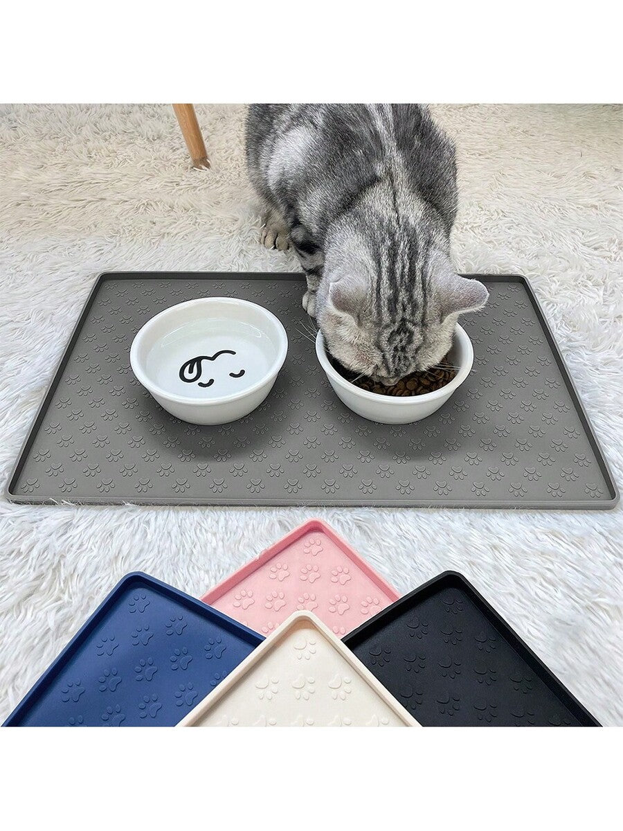 Beige silicone pet placemat with embossed paw print accents designed to catch food and water spills for dogs and cats.