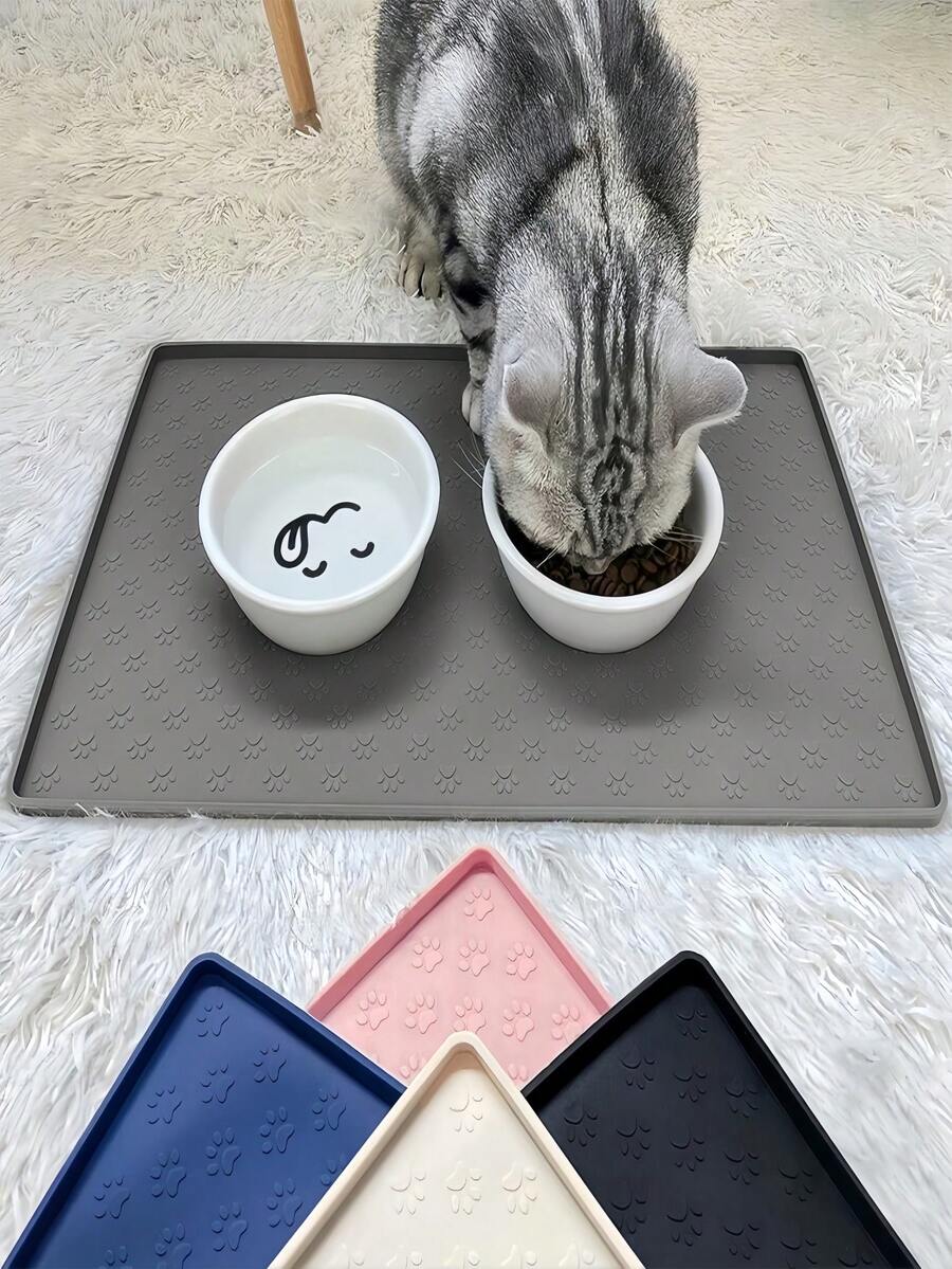 Black and white cartoon diatomite pet feeding mat placed under dog and cat food and water bowls to catch spills.