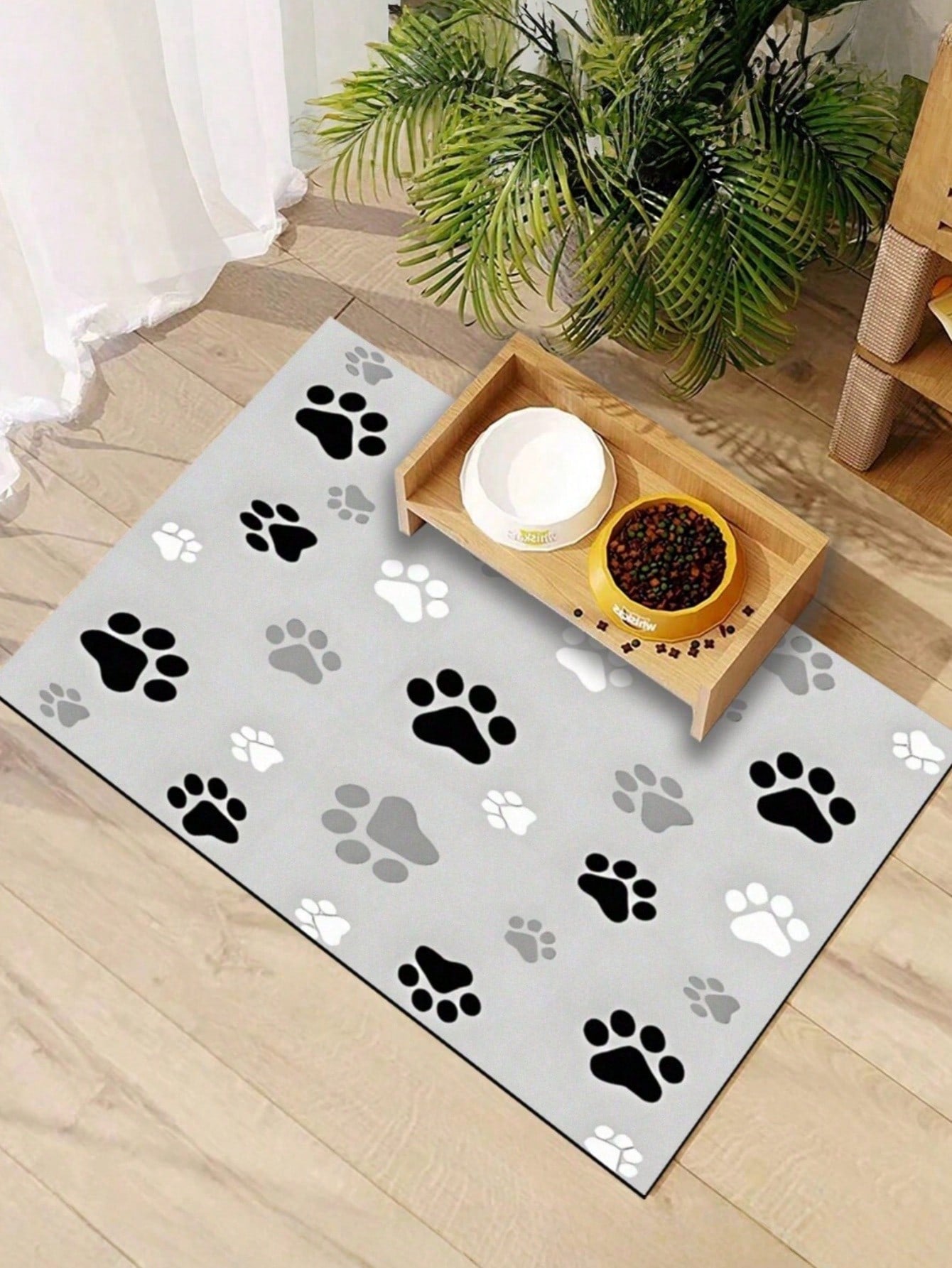 Black and white cartoon diatomite pet feeding mat placed under dog and cat food and water bowls to catch spills.