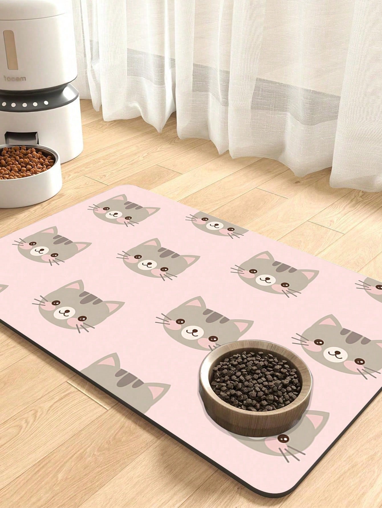 Black and white cartoon diatomite pet feeding mat placed under dog and cat food and water bowls to catch spills.