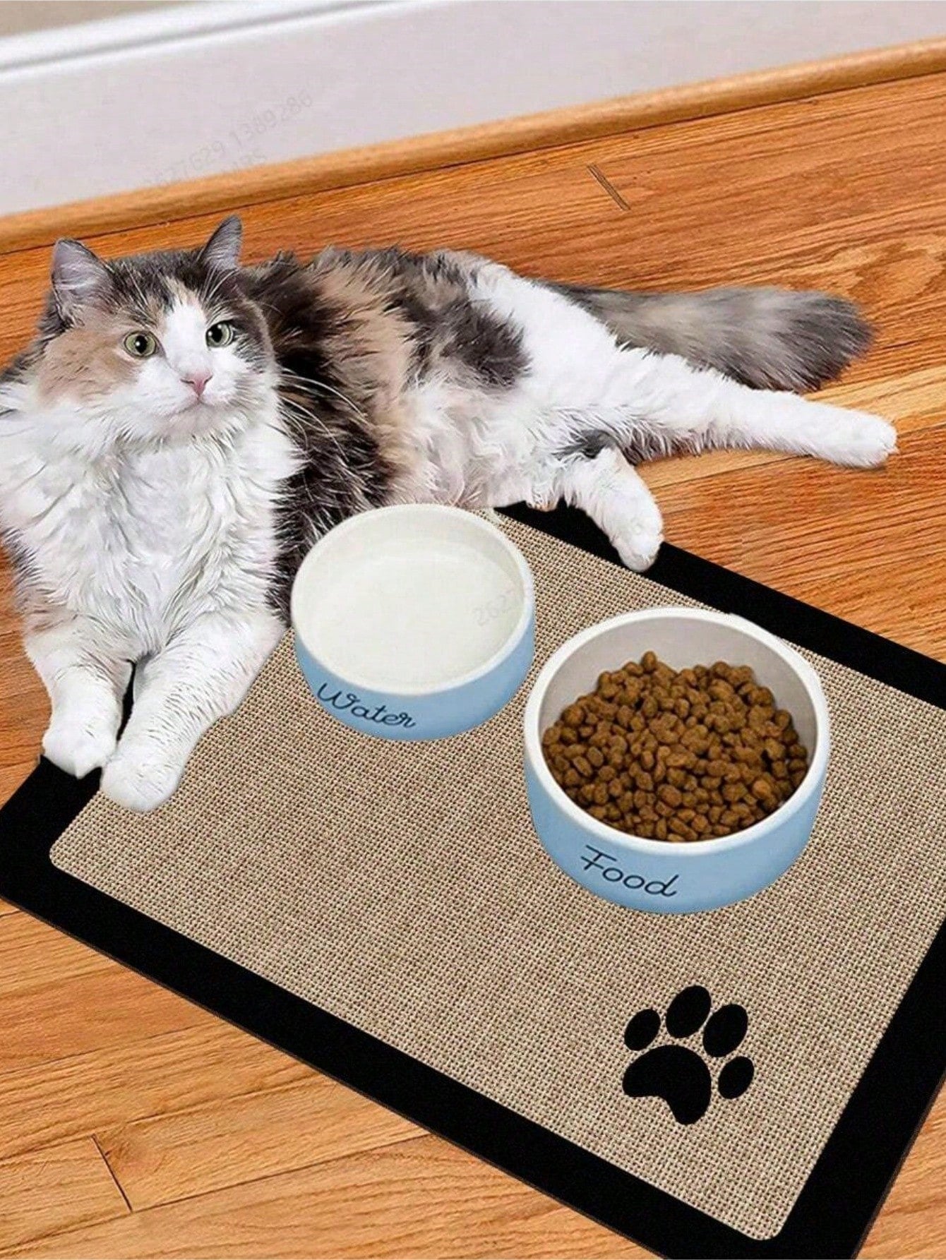 Black and white cartoon diatomite pet feeding mat placed under dog and cat food and water bowls to catch spills.