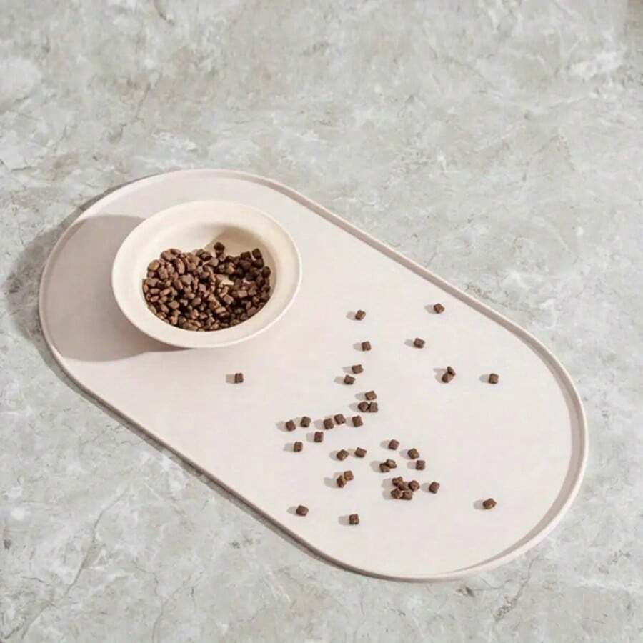 Beige oval silicone pet food mat with anti-slip and waterproof design for cat and dog bowls