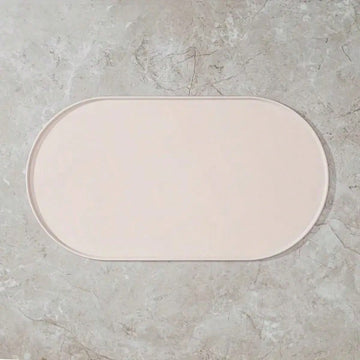 Beige oval silicone pet food mat with anti-slip and waterproof design for cat and dog bowls