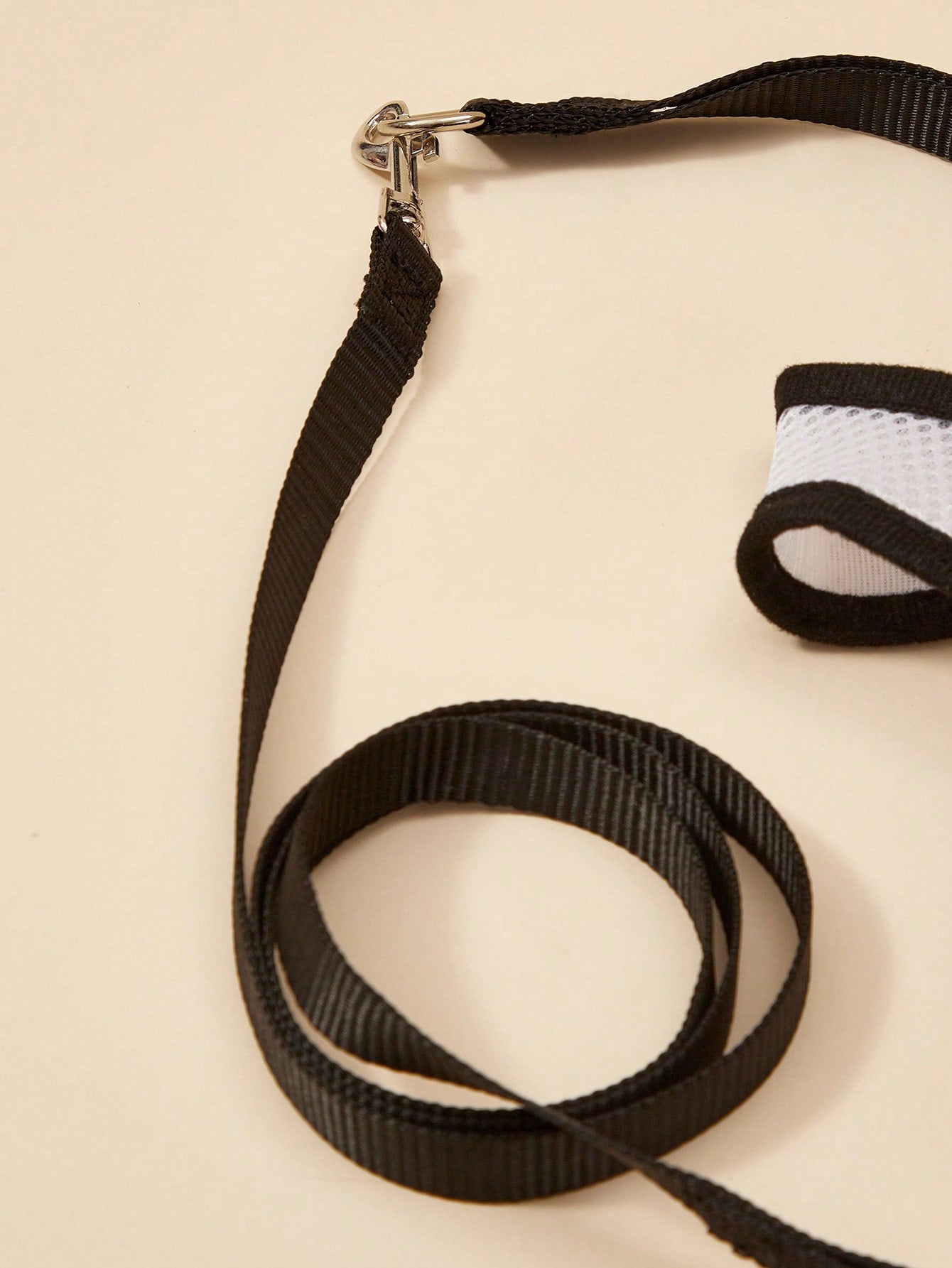 Black polyamide pet chest harness and back strap with leash for walking small and medium cats or dogs.