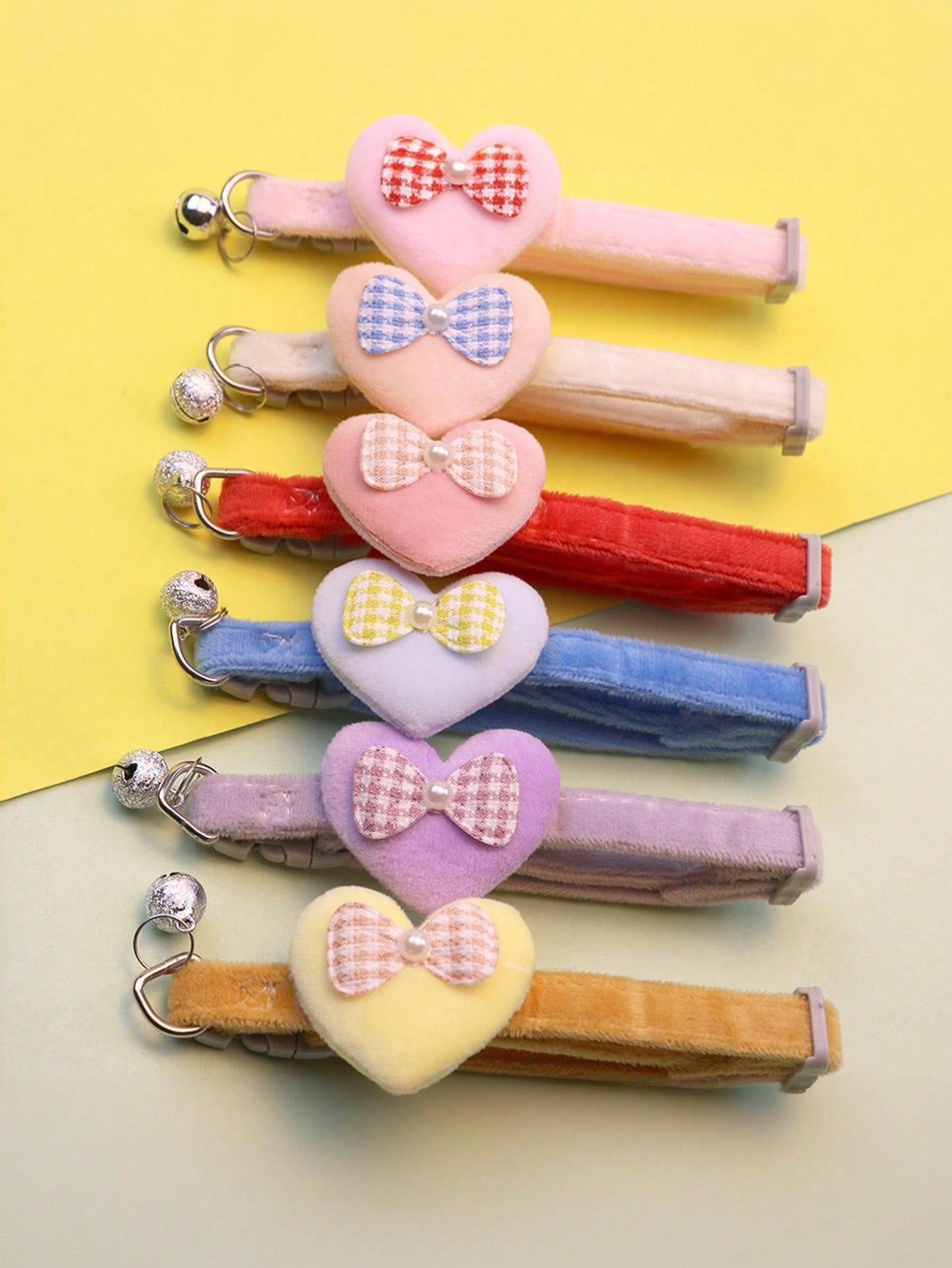 Multicolor adjustable polyester pet collar with cartoon heart-shaped bow decoration and bell pendant for small and medium cats and dogs.