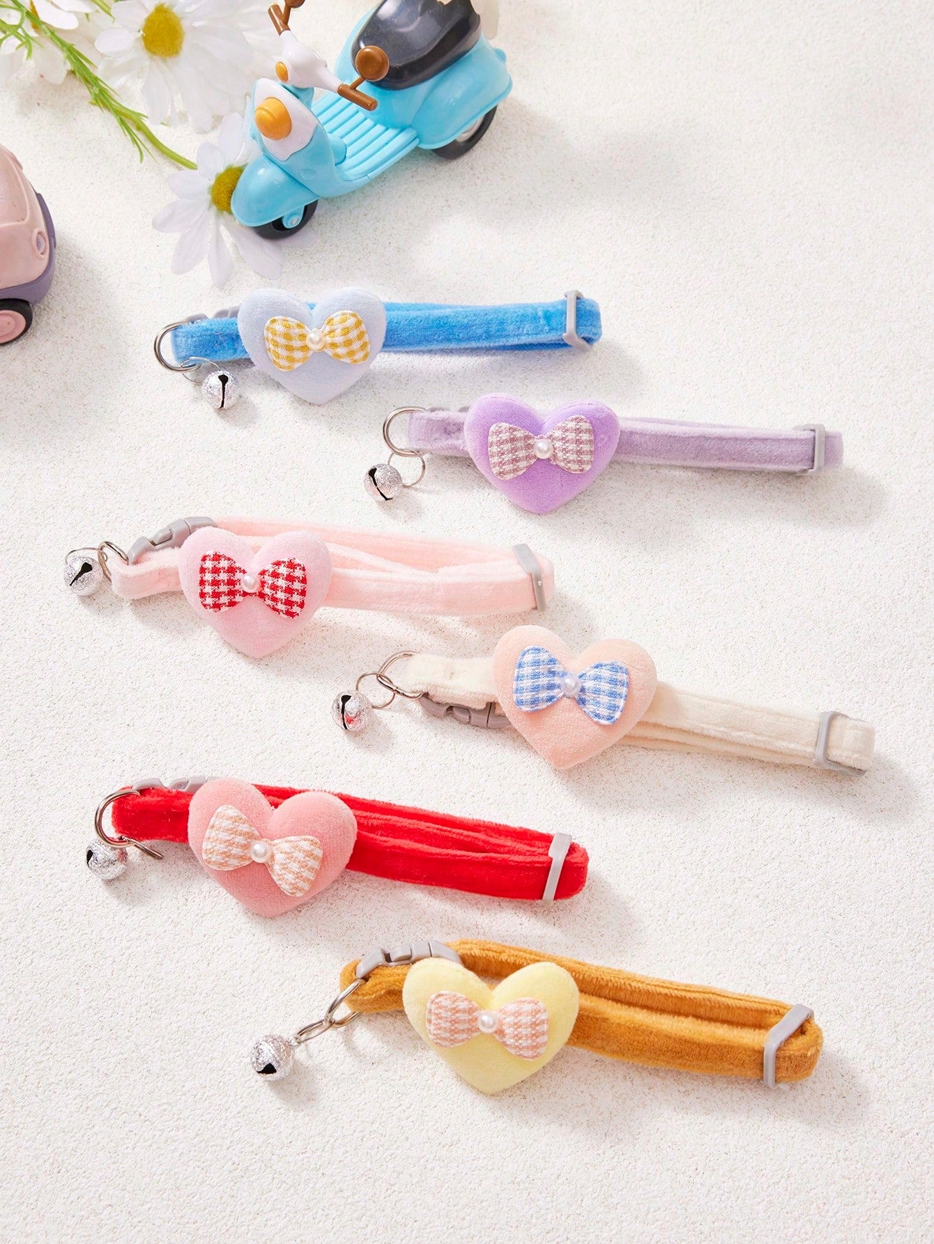 Multicolor adjustable polyester pet collar with cartoon heart-shaped bow decoration and bell pendant for small and medium cats and dogs.