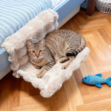 Plush cat bedside hammock bed hung on a bed edge, featuring soft warm polyester cushion for small cats and dogs.