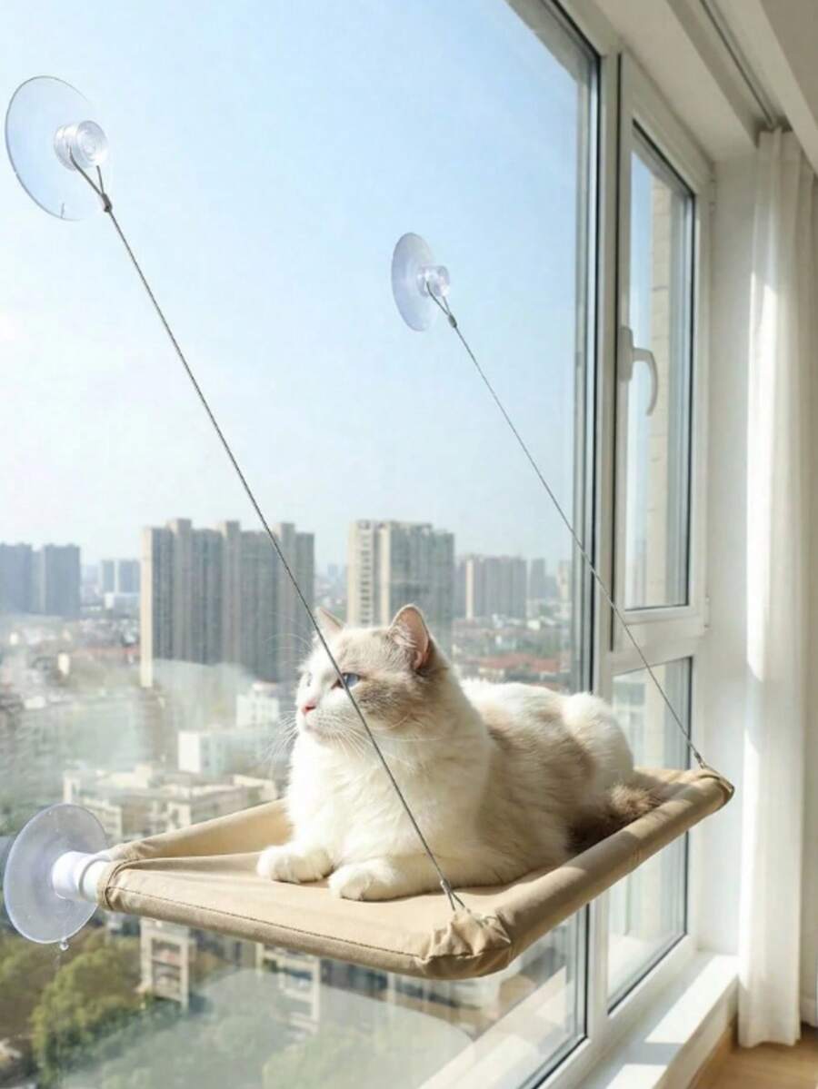 Suspended cat window hammock bed with sturdy ABS frame, mounting brackets, and cozy blanket installed on a glass window.