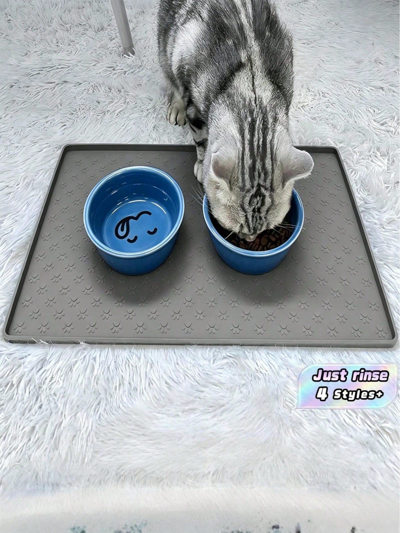 Black and white cartoon diatomite pet feeding mat placed under dog and cat food and water bowls to catch spills.
