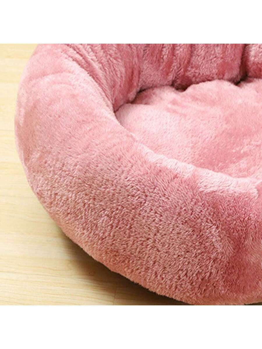 Pink round plush pet bed made of soft short plush material for small and medium cats and dogs.