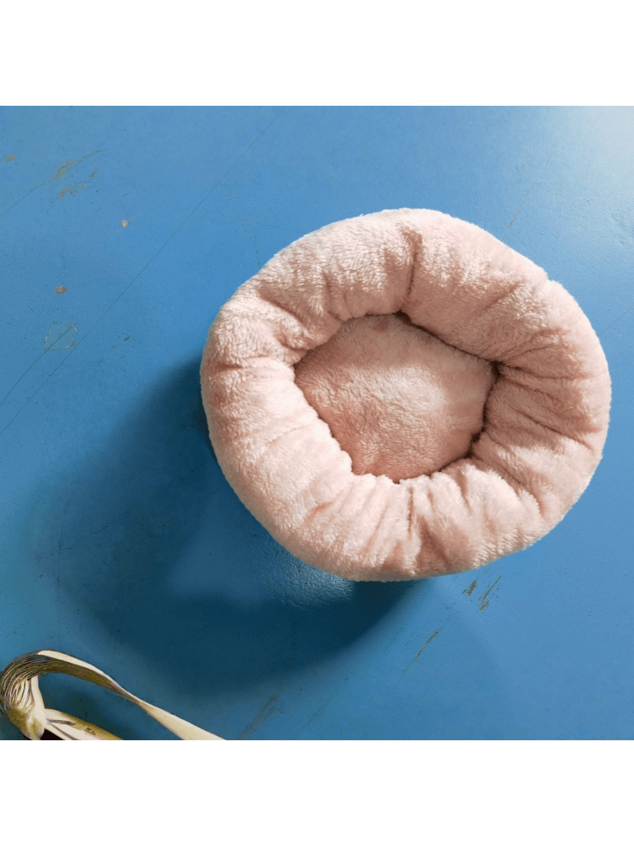 Pink round plush pet bed made of soft short plush material for small and medium cats and dogs.