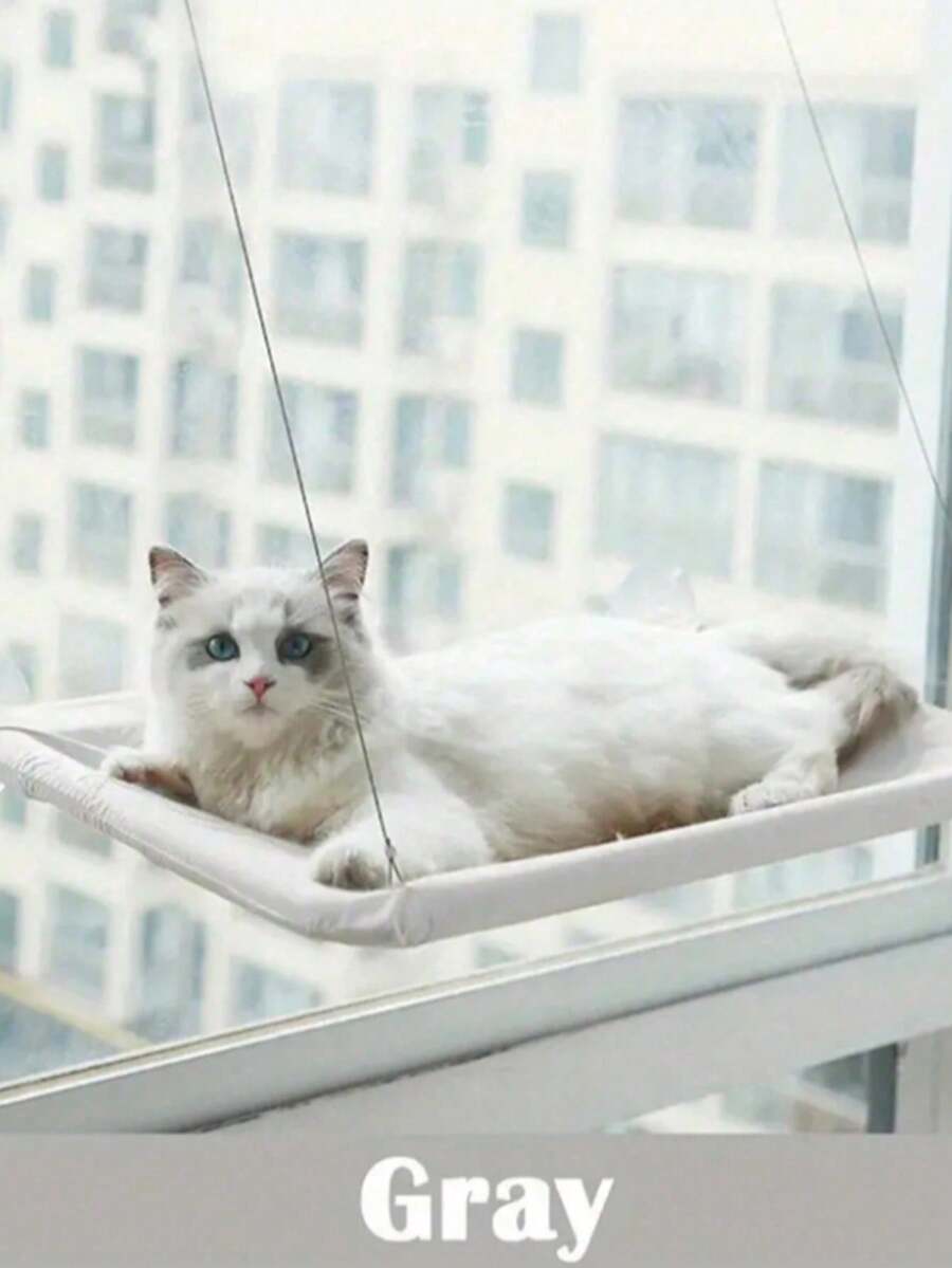 Suspended cat window hammock bed with sturdy ABS frame, mounting brackets, and cozy blanket installed on a glass window.