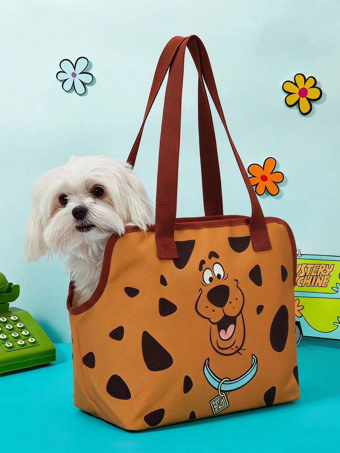Brown soft-sided pet carrier tote bag featuring a cartoon dog print, carrying handles, and a detachable shoulder strap for travel.