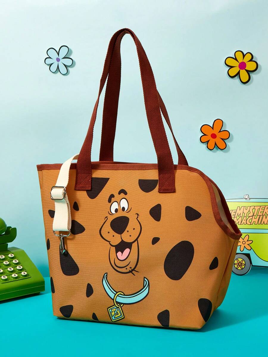 Brown soft-sided pet carrier tote bag featuring a cartoon dog print, carrying handles, and a detachable shoulder strap for travel.