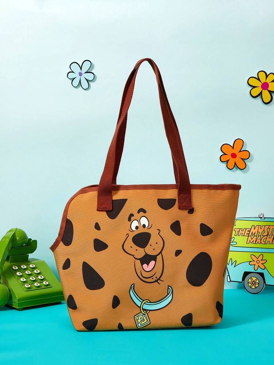 Brown soft-sided pet carrier tote bag featuring a cartoon dog print, carrying handles, and a detachable shoulder strap for travel.