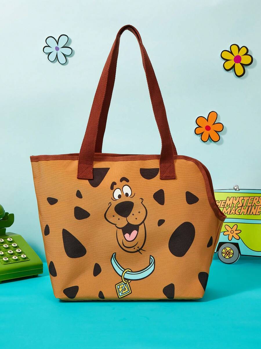Brown soft-sided pet carrier tote bag featuring a cartoon dog print, carrying handles, and a detachable shoulder strap for travel.