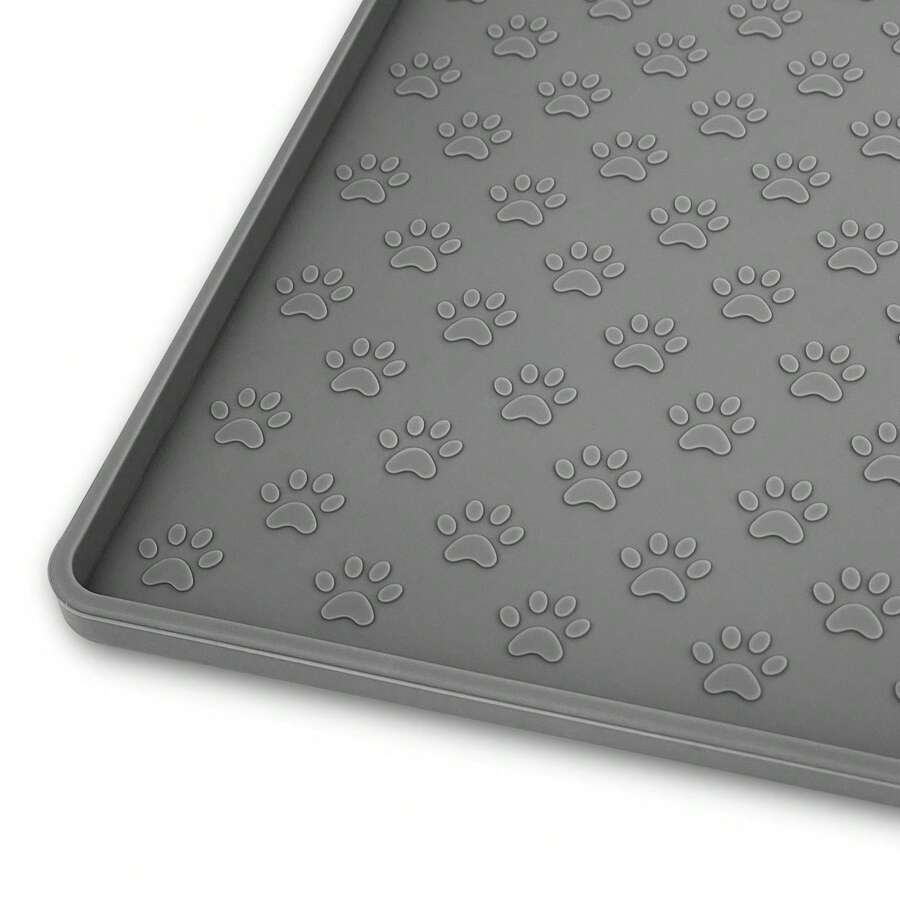 Beige silicone pet placemat with embossed paw print accents designed to catch food and water spills for dogs and cats.