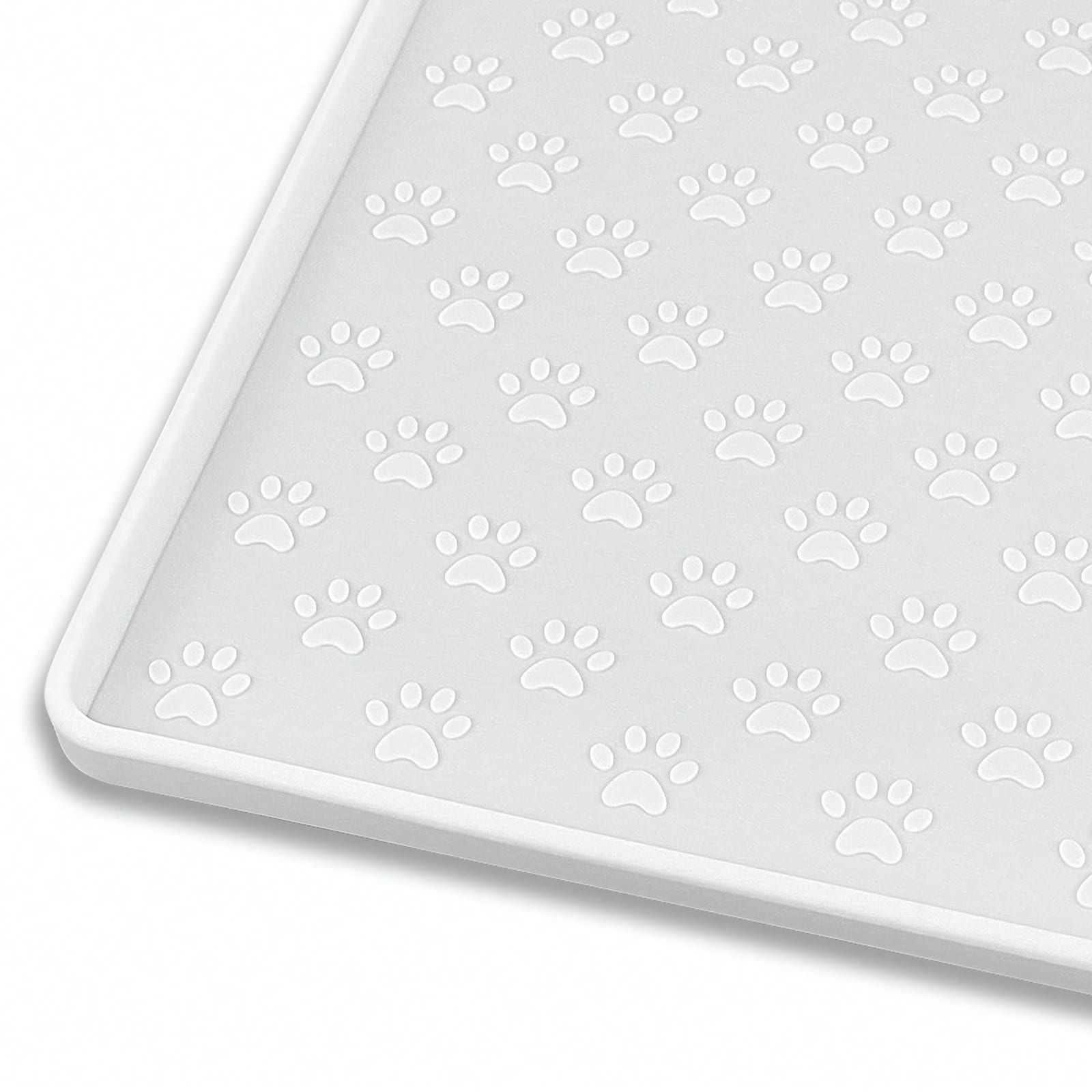 Beige silicone pet placemat with embossed paw print accents designed to catch food and water spills for dogs and cats.