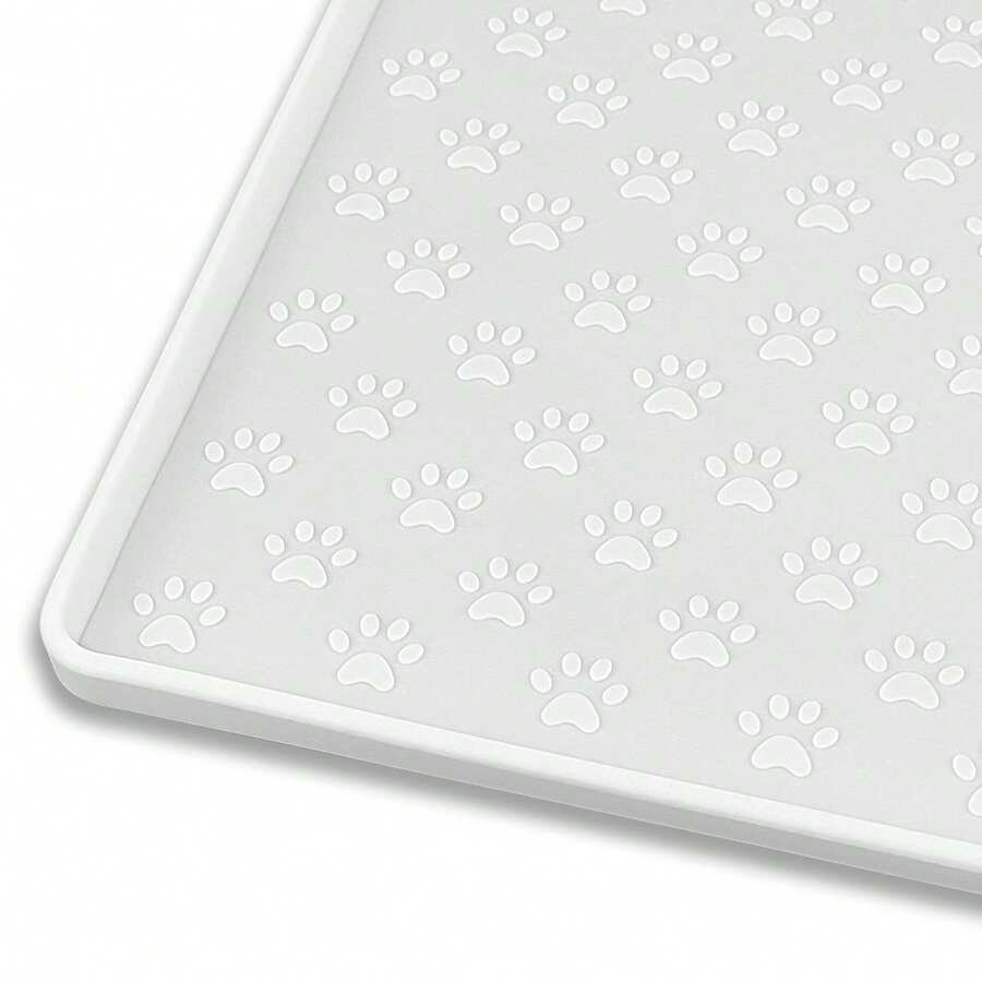 Beige silicone pet placemat with embossed paw print accents designed to catch food and water spills for dogs and cats.