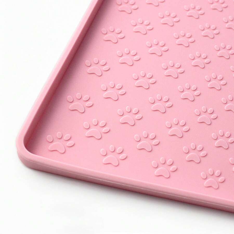 Beige silicone pet placemat with embossed paw print accents designed to catch food and water spills for dogs and cats.